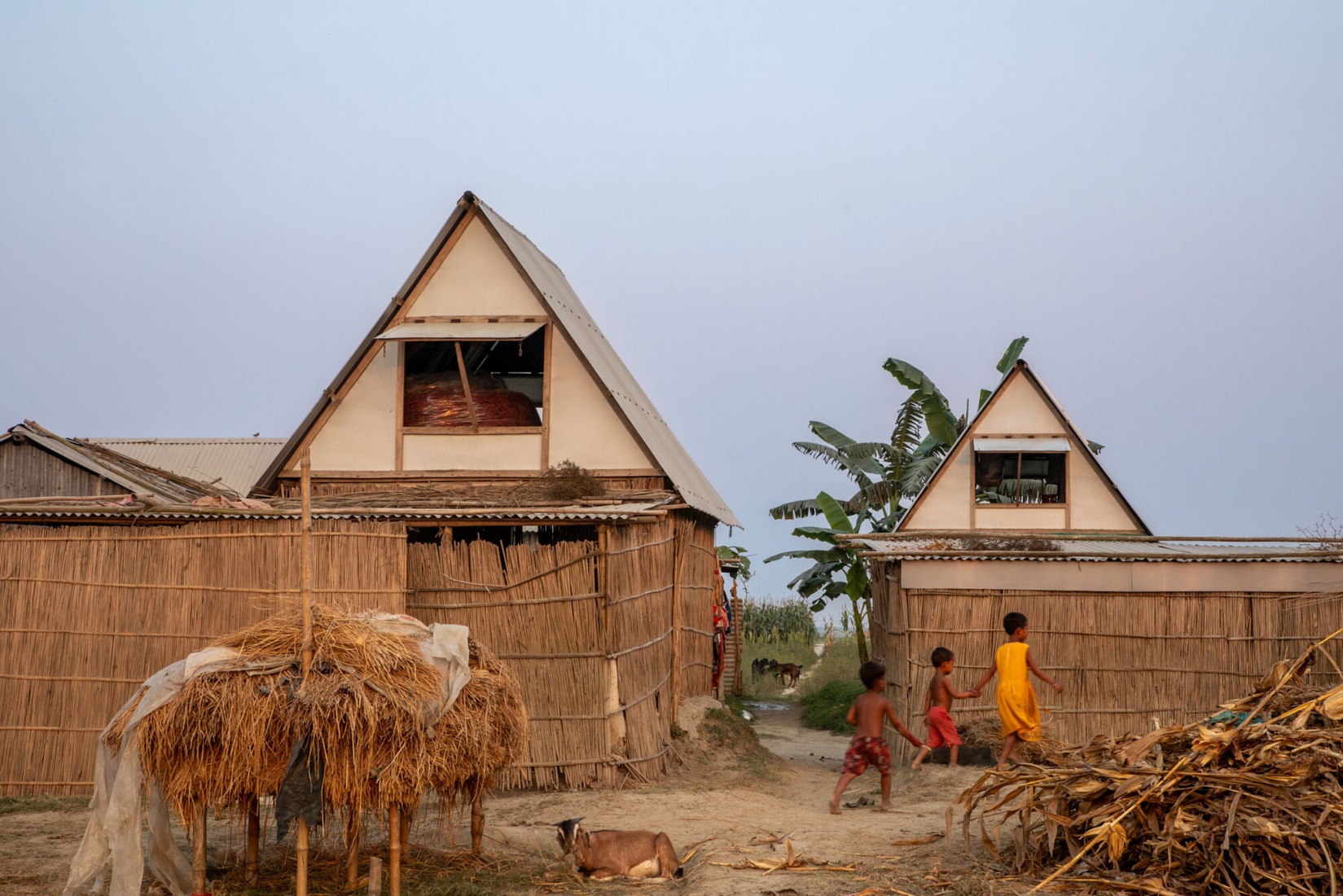 People living on these ephemeral shoals are vulnerable to floods and land erosion. The distinctive two-story Khudi Bari structure enables them to stay through the rainy season, transforming how they inhabit the char. Aga Khan Trust for Culture / City Syntax (F. M. Faruque Abdullah Shawon, H. M. Fozla Rabby Apurbo). People living on these ephemeral shoals are vulnerable to floods and land erosion. The distinctive two-story Khudi Bari structure enables them to stay through the rainy season, transforming how they inhabit the char. Aga Khan Trust for Culture / City Syntax (F. M. Faruque Abdullah Shawon, H. M. Fozla Rabby Apurbo).