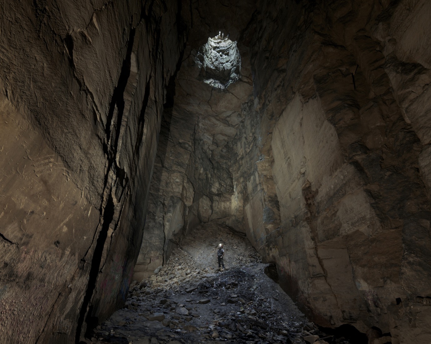 The photographer stood within the Cathedral, the largest open space within this subterranean stone quarry in Wiltshire, UK. Photograph © Matthew Emmett.