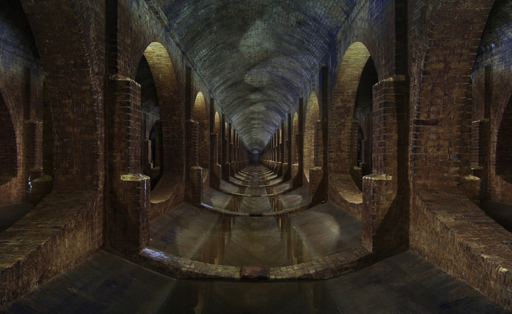 Rows of brick arches within a Victorian era underground cistern. Used for the storage of drinking water. Long since disused. Photograph © Matthew Emmett.