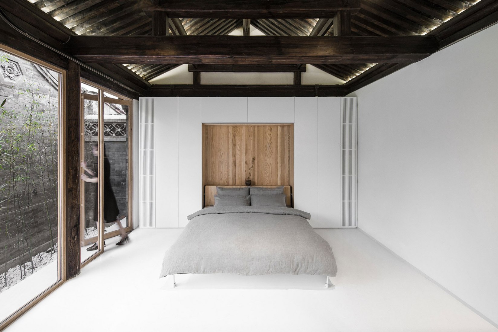 Mobiliario insertado en paredes, para espacios cambiantes. Patio plegado por Archstudio. Fotografía © Wang Ning & Jin Weiqi.inserted into the existing wood frames of east and west wings. Twisting Courtyard by Archstudio. Photography © Wang Ning & Jin Weiqi