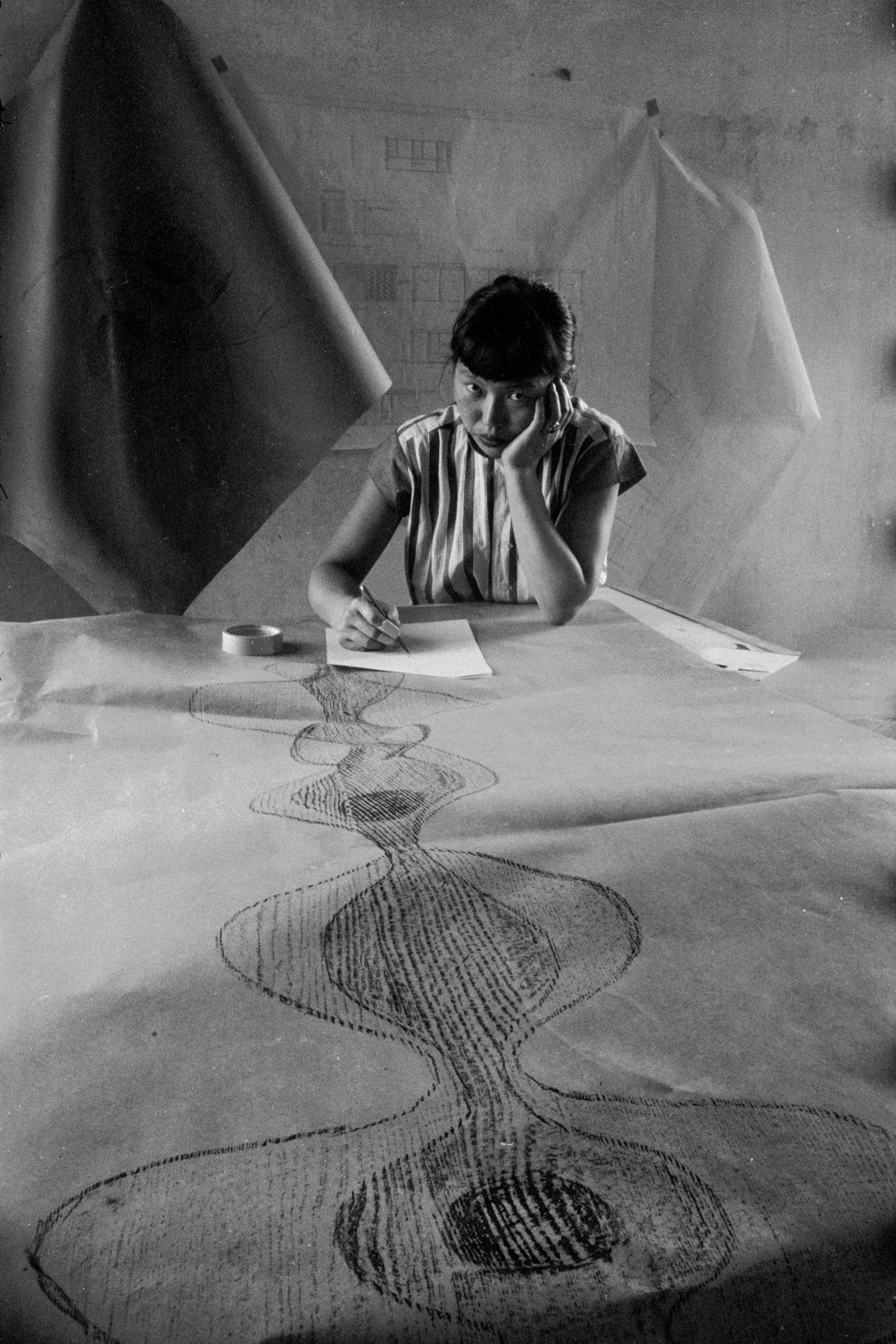 Portrait of artist Ruth Asawa as she sketches a design