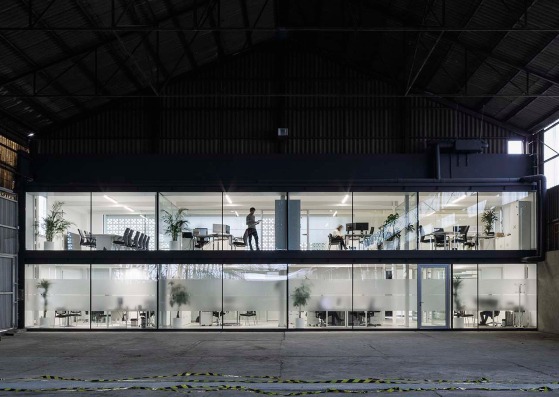 View towards an old industrial warehouse. Trucksur Offices by Eovastudio