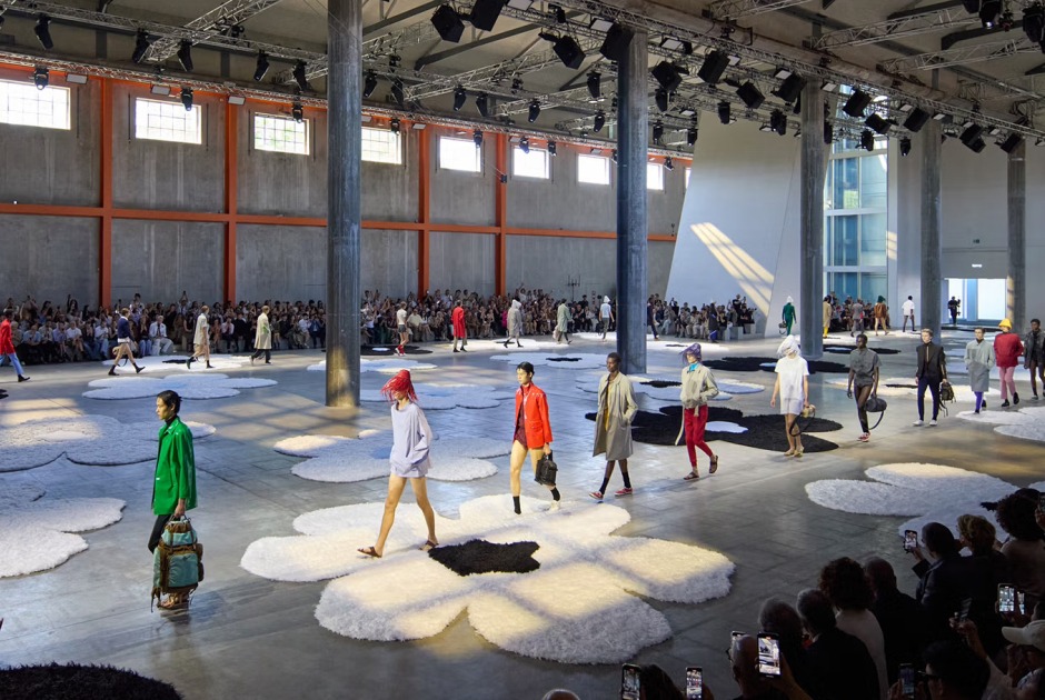 Prada’s show set at Milan Fashion Week S/S 2026, with the Deposito space at Fondazione Prada windows opened, allowing light in. Photograph courtesy of Prada Prada’s show set at Milan Fashion Week S/S 2026, with the Deposito space at Fondazione Prada windows opened, allowing light in. Photograph courtesy of Prada