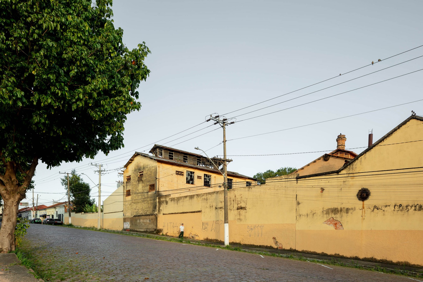 Street view of the Atelier K and the Building P, still untouched. Fábrica de Arte Marcos Amaro (FAMA) by KAAN. Photograph by Sebastian van Damme.