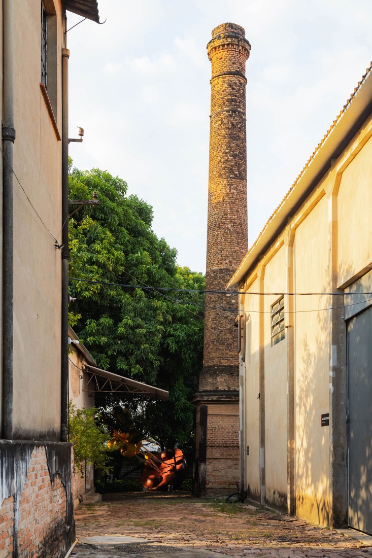 View of the Chimney Q, the Residential Atelier I and the Exhibition Building J.  Fábrica de Arte Marcos Amaro (FAMA) by KAAN. Photograph by Sebastian van Damme.