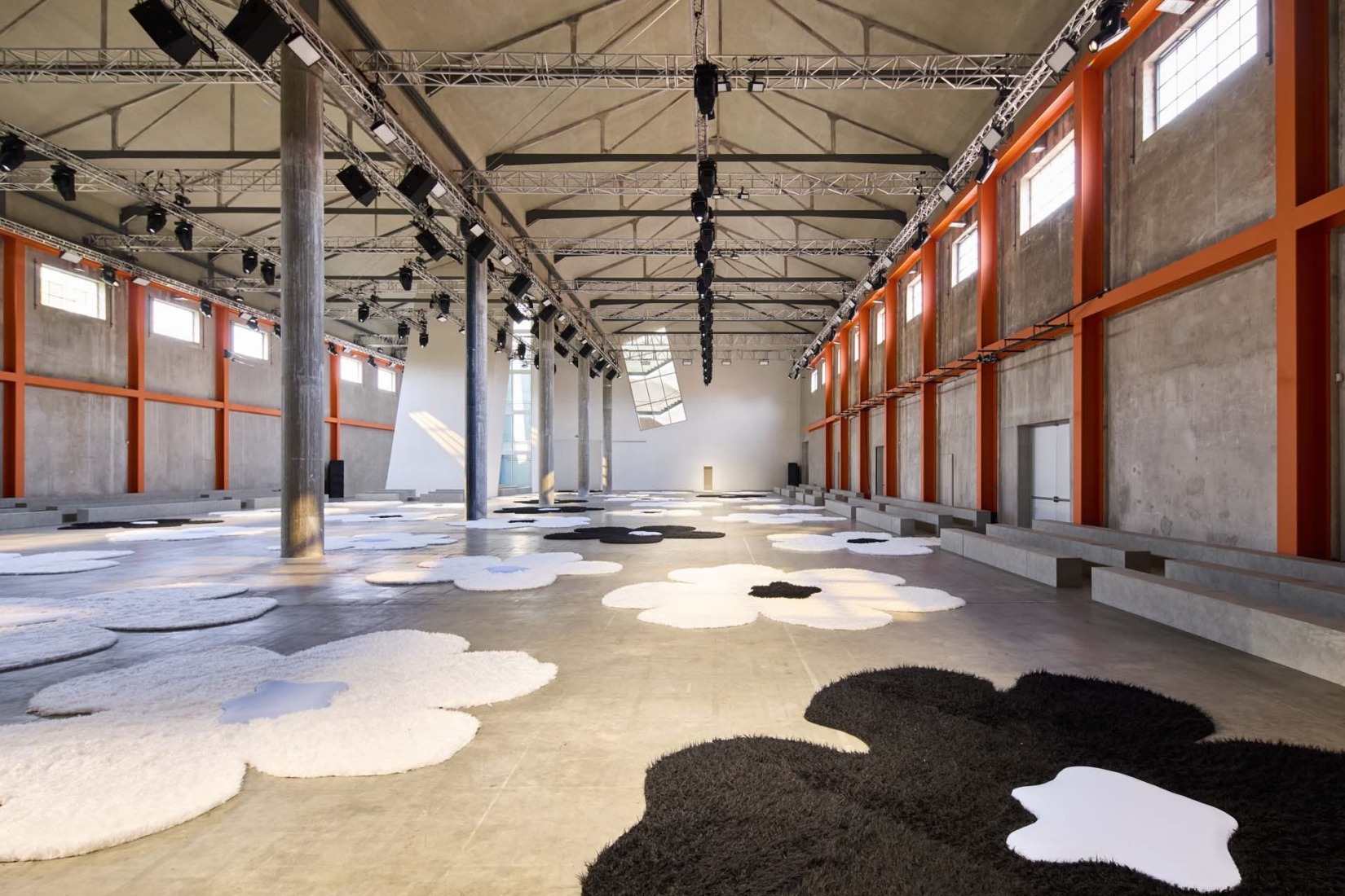 Prada’s show set at Milan Fashion Week S/S 2026, with the Deposito space at Fondazione Prada windows opened, allowing light in. Photograph courtesy of Prada.