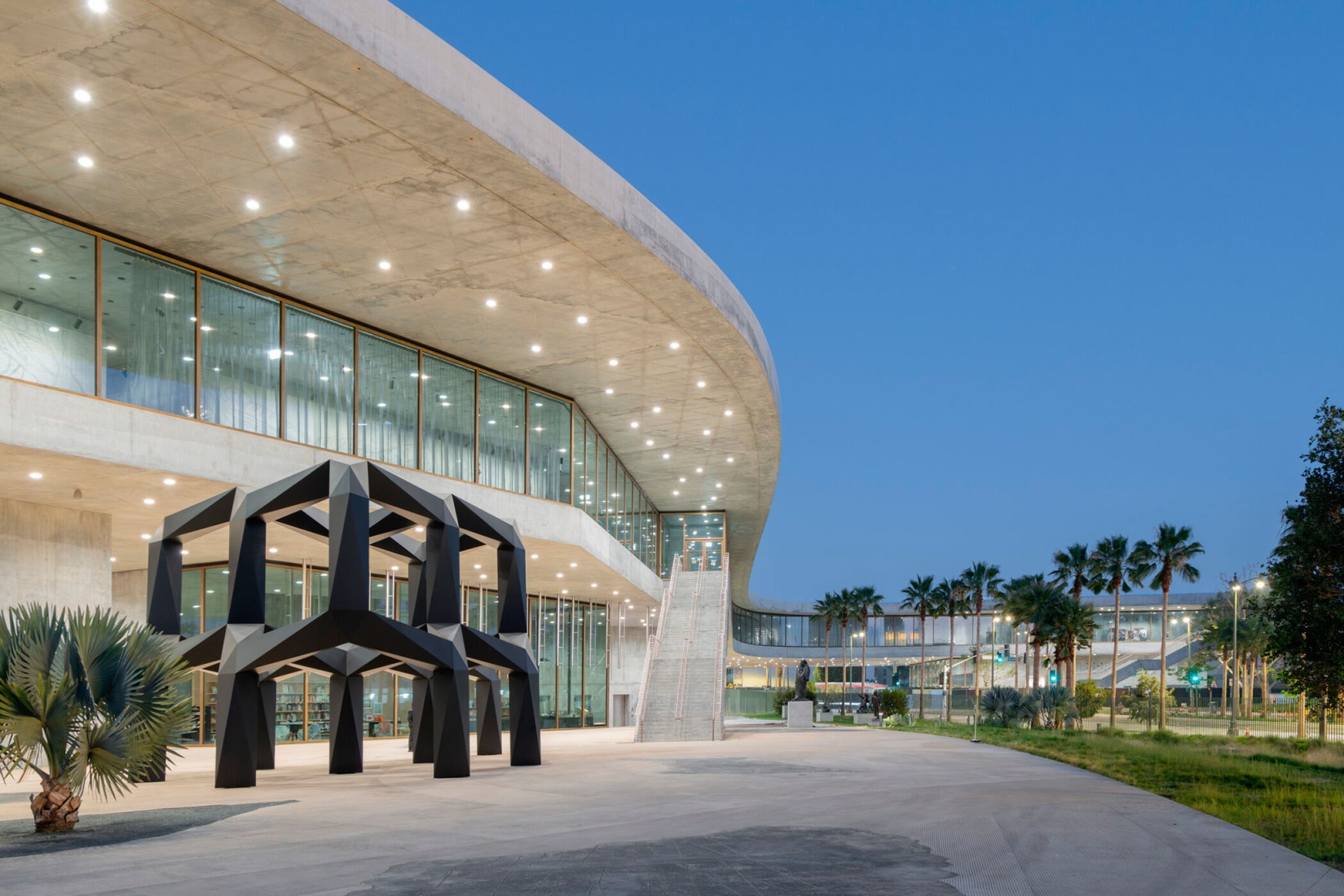 Vista exterior hacia el sureste en dirección a Wilshire Boulevard con Smoke (1967) de Tony Smith en primer plano, Galerías David Geffen en LACMA, arte © Tony Smith Estate/Artists Rights Society (ARS), Nueva York. Fotografía por Iwan Baan, cortesía de Museum Associates/LACMA.