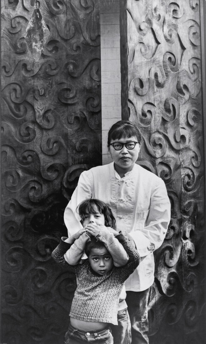 Ruth Asawa with her children, Addie and Paul, in front of Doors (S.528, Carved Redwood Doors for Ruth Asawa’s Home), ca. 1965. Photograph by Joan Pearson Watkins. Copyright 2026 Ruth Asawa Lanier, Inc., courtesy of David Zwirner.