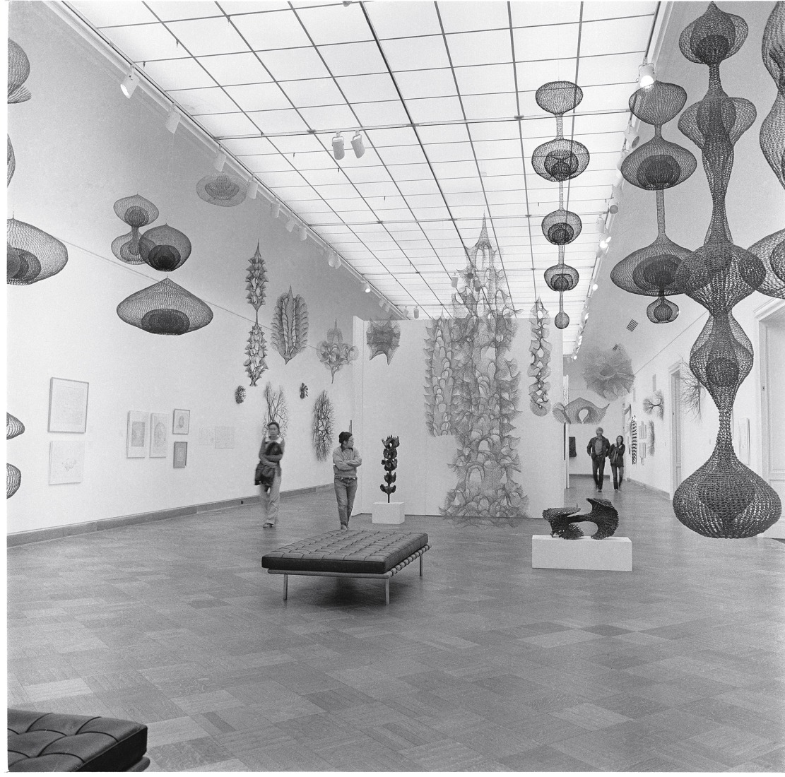 Ruth Asawa (second from the left) with visitors at the exhibition Ruth Asawa: A Retrospective View, San Francisco Museum of Art (now SFMOMA), 1973. Copyright 2026 Ruth Asawa Lanier, Inc., courtesy of David Zwirner. Photograph by Laurence Cuneo.