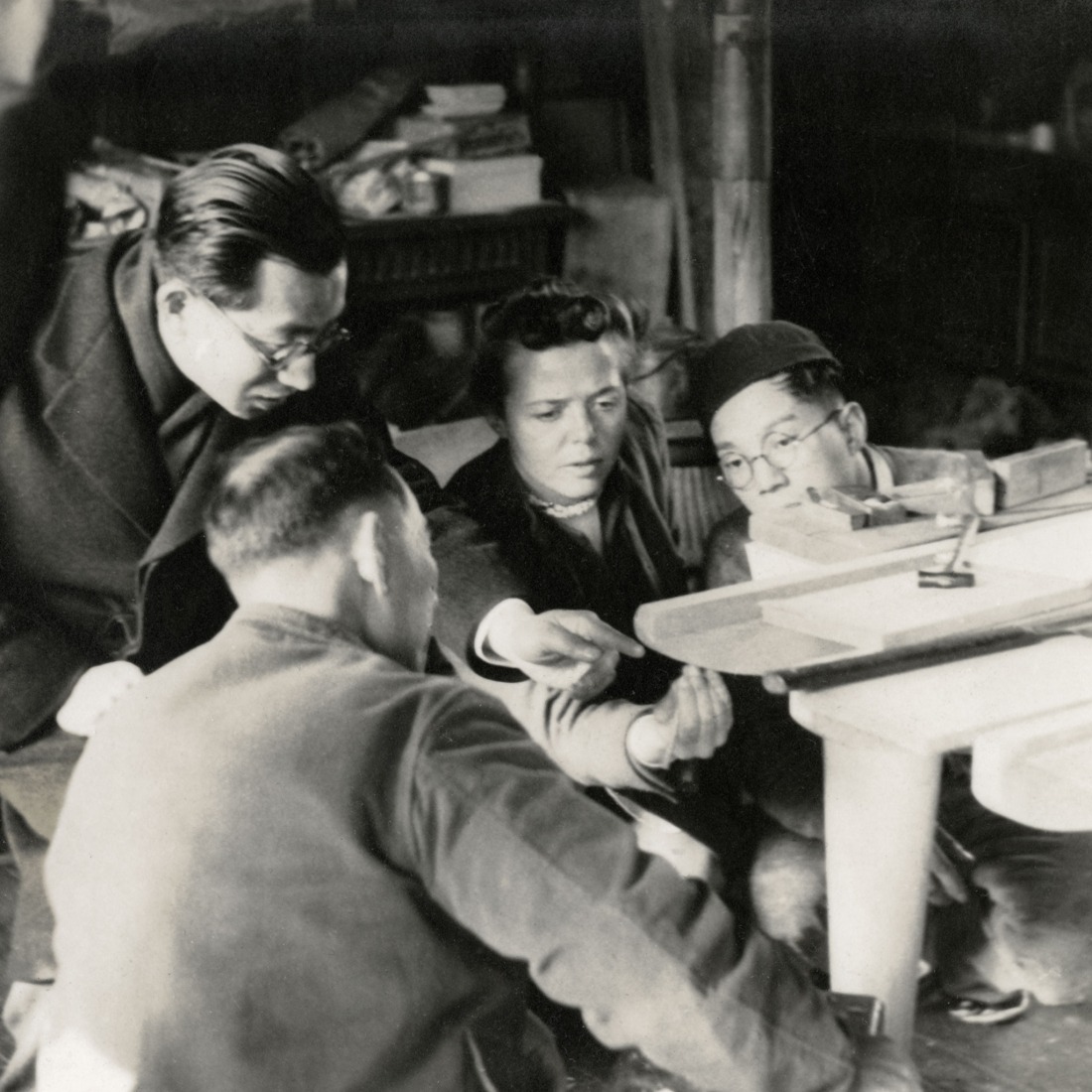 Charlotte Perriand estudia la fabricación de una mesa de tablero de pino con dos ebanistas: uno de ellos, en primer plano, es Jirô Hayashi; a la izquierda, Junzô Sakakura traduce sus palabras, 1940. Fotógrafo desconocido. Cortesía de Archives Charlotte Perriand, 2026. VEGAP, Barcelona 2026.