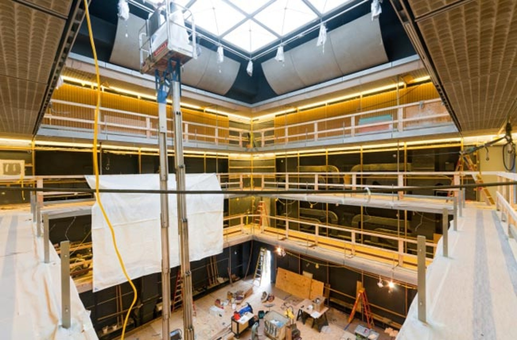 Installing Wall Panel System in Hall. The wooden panel system that makes up the final wall finishes in the performance hall are beginning to be installed at the third balcony level.