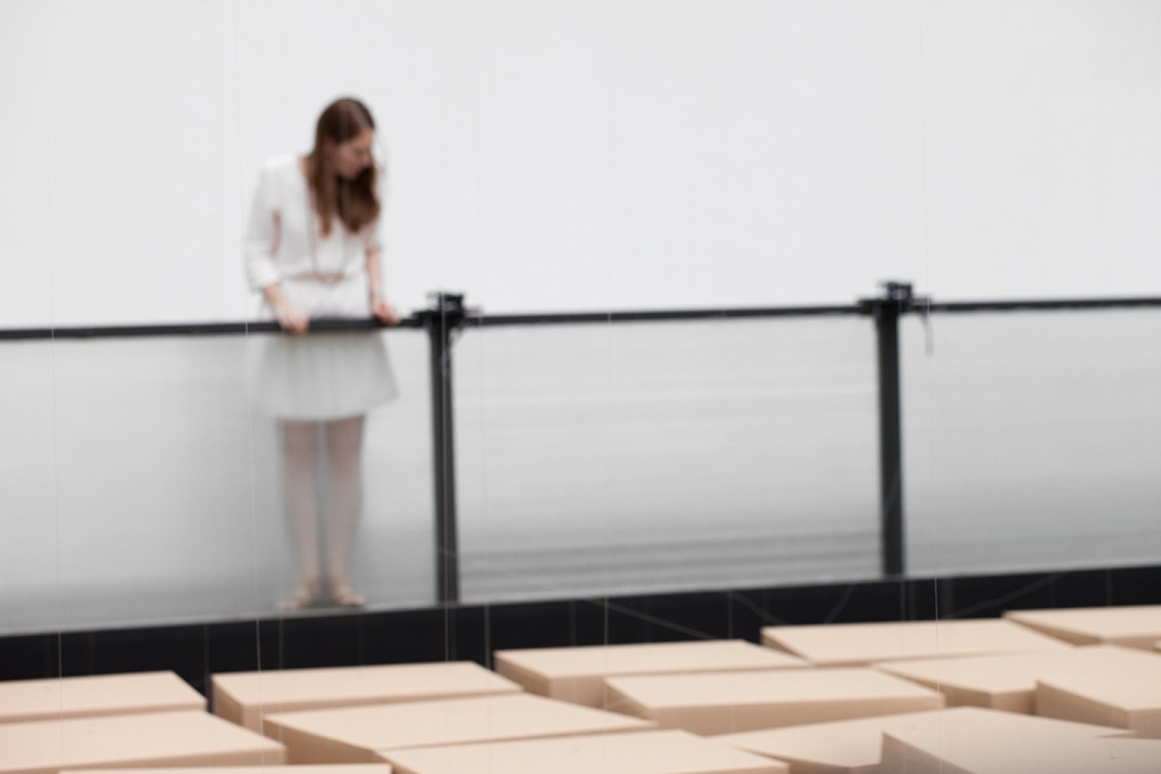Visitante mirando la instalación. 20 dc-motores preparados, 81 cajas de cartón de 70x70x70cm. Zimoun y H. Zweifel. Imagen cortesía de Studio Zimoun.