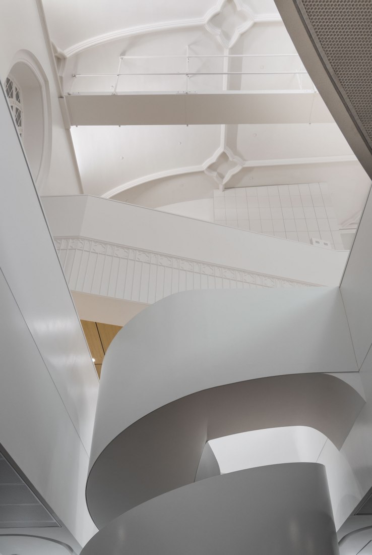 The sculptural white spiral staircase. Maison de la littérature (House of Literature) by Chevalier Morales Architectes. Photograph by Chevalier Morales Architectes.
