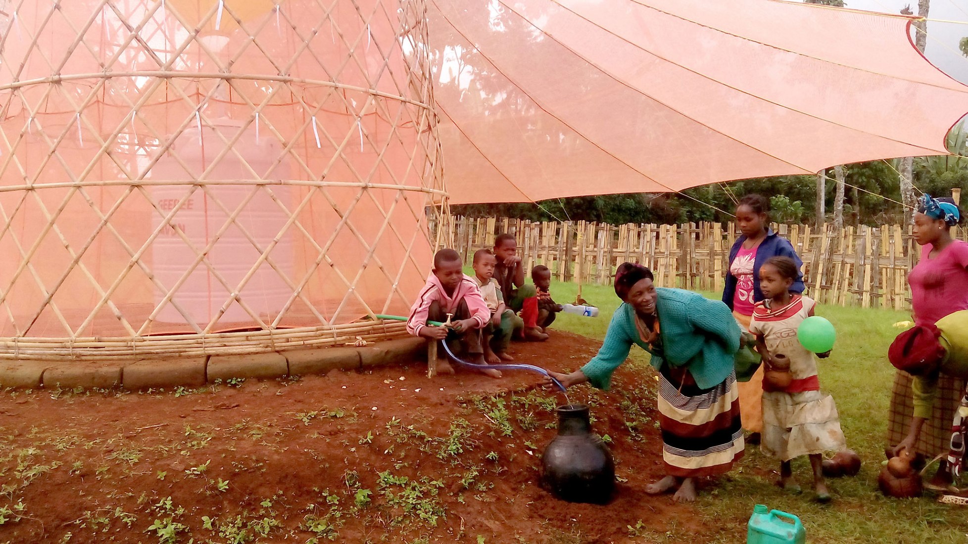 Women fetching water and children playing. Warka Water by Arturo Vittori. Photograph © Architecture and Vision / Arturo Vittori.