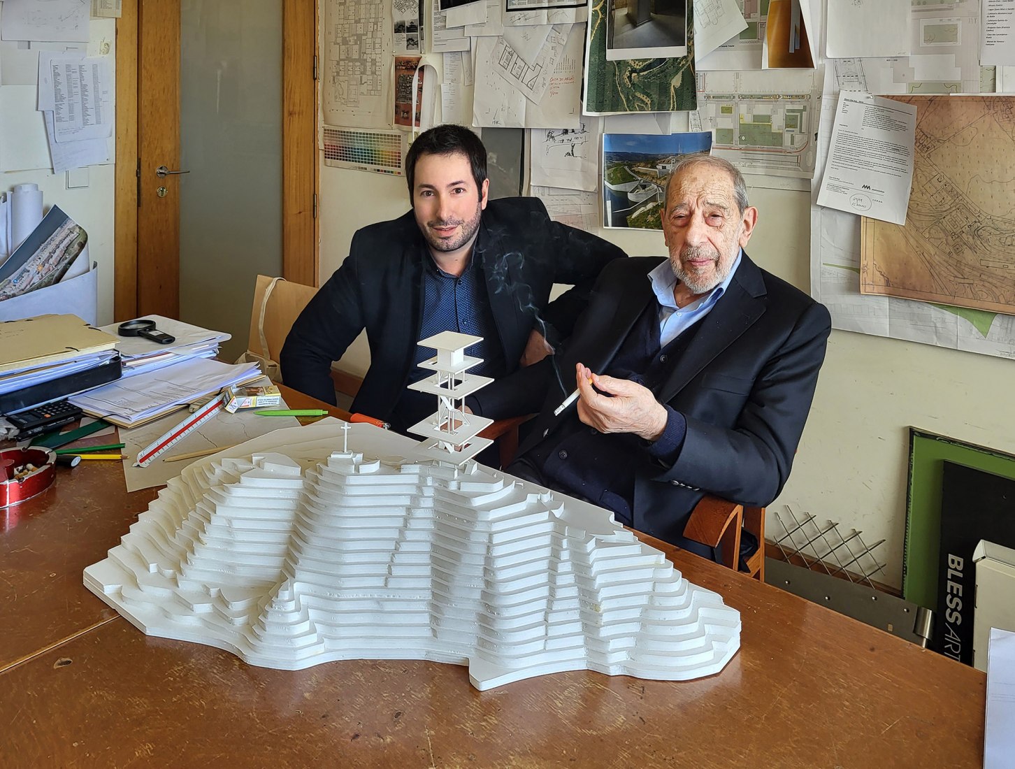 El arquitecto y comisario António Choupina con el arquitecto Álvaro Siza y una maqueta de la torre en Proença-a-Nova. Fotografía por Marc Dubois.