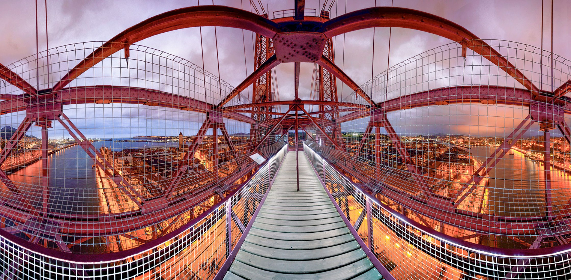 Puente Bizkaia. Fotógrafo: Pedro Luis Ajuriaguerra Saiz Cámara utilizada: Sony ALPHA a7 RIV ILCE-7RM4. Comentarios del fotógrafo: El Puente Bizkaia, también conocido como Puente Colgante, es Patrimonio de la Humanidad por la UNESCO desde 2006, fue construido por Ferdinand Arnodin, discípulo directo de Eiffel, en 1893. Situado en el tramo final de la Ruta de Bilbao, a la derecha en el lugar donde el mar se encuentra con el Nervión, esta espectacular estructura de hierro une el barrio de Las Arenas y Portugal