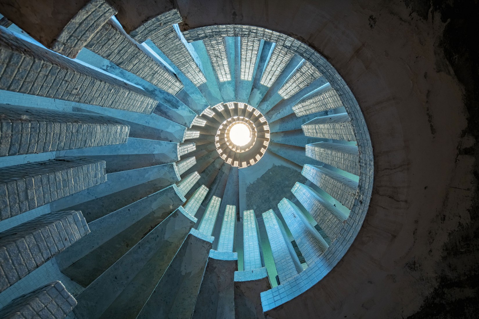 Engranajes.  Fotógrafo: Gina Soden. Cámara utilizada: Nikon D850. Comentarios del fotógrafo: Una inusual escalera de baldosas de hormigón en una mansión abandonada. 
