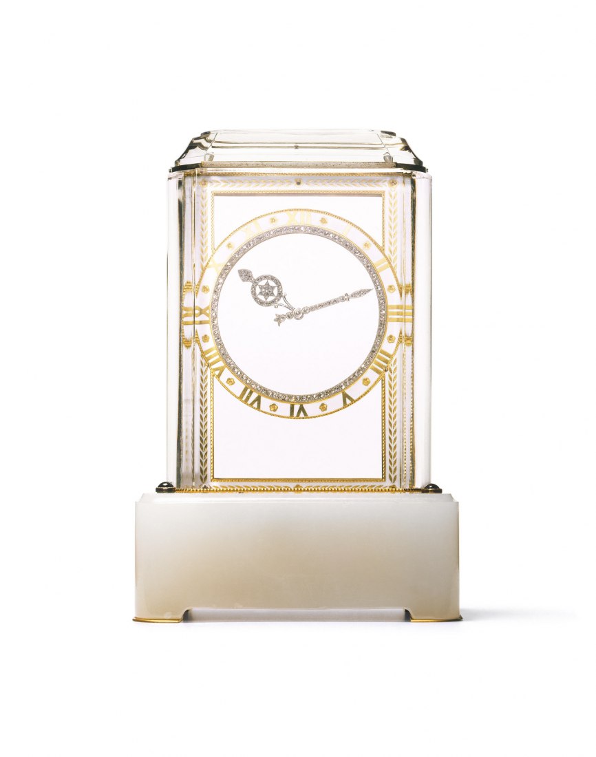 Modelo del reloj "A mistery clock", 1914 Cartier Paris, en platino, oro, agarr, 4 piedras de zafiro y diamantes. El primer modelo "A mistery clock" fue vendido por Cartier en 1912. Son misteriosos porque sus manos de platino y diamante no parecen estar vinculado a cualquier movimiento mecánico. De hecho cada mano del reloj se fija en un disco plano del vidrio con un borde oculto, dentado; Los discos son accionados por dos bastidores verticales ocultos en los lados del reloj; Estos bastidores son impulsados 