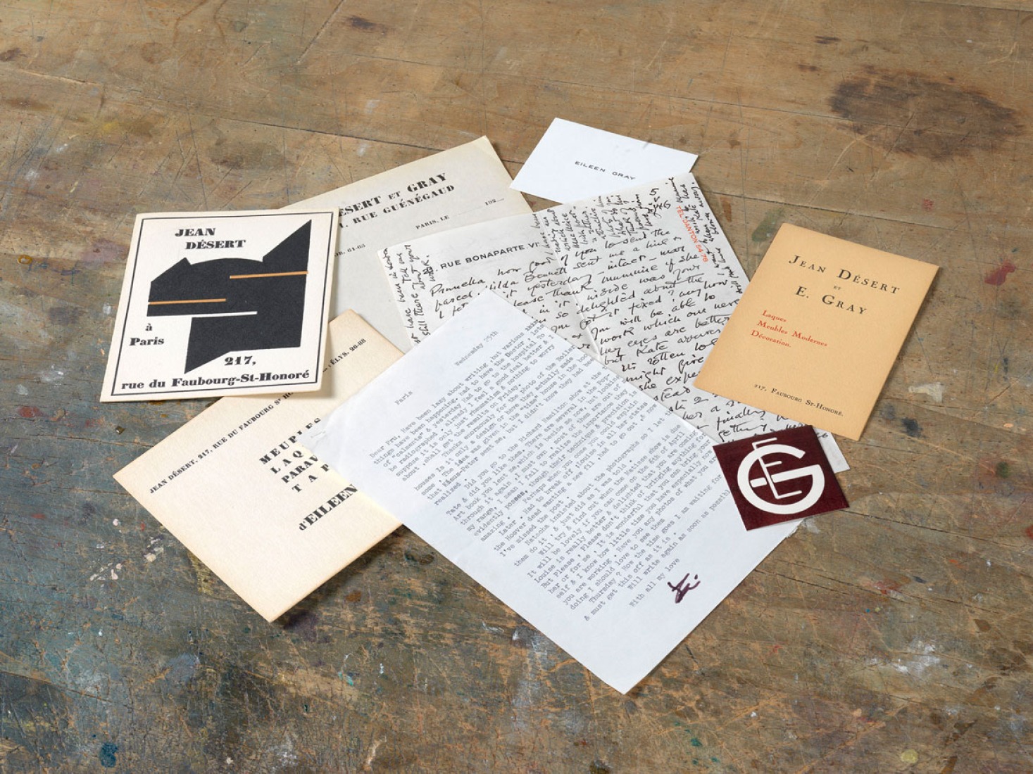 Papelería: manuscritos y la correspondencia entre Eileen Gray y Prunella Clough, tarjeta de visita, tarjeta de invitación, anuncio y sello de Eileen Gray. Exposición Eileen Gray: la pintora privada. Imagen cortesía de la Osborne Samuel Gallery.