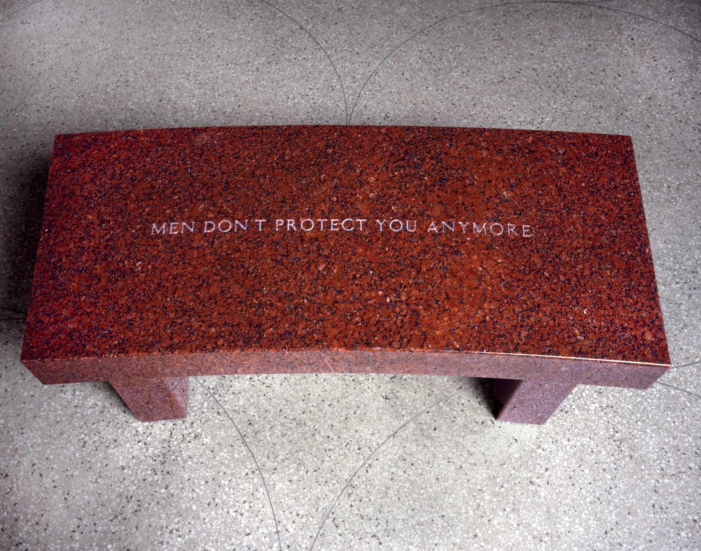 Jenny Holzer. Survival: Men don't protect... (Supervivencia: Los hombres ya no te protegen...), 1989. Banco de granito rojo indio 43,2 x 106,7 x 45,7 cm. Texto: Survival, 1983–85. Cortesía de la artista © 2019 Jenny Holzer, member Artists Rights Society (ARS), NY/VEGAP. Fotografía de Larry Lame.