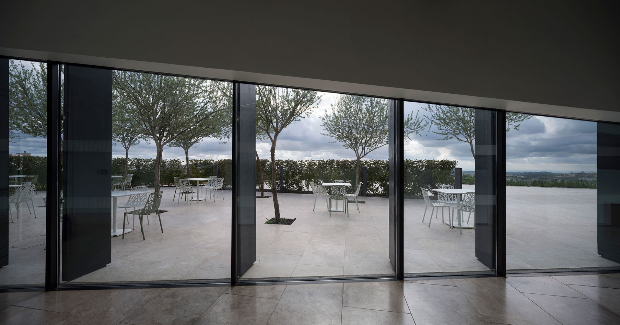 El espacio de entrada central se abre a una terraza pavimentada de piedra con vistas a los jardines. Fotografía © Aga Khan Trust for Culture / Cemal Emden.