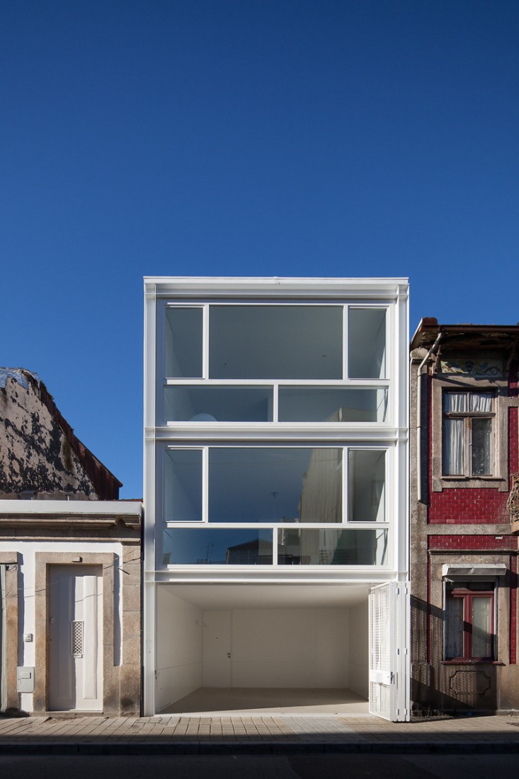 Front façade: open shutters. Urban House in Lindo Vale by Ana Cláudia Monteiro + Vítor Oliveira. Photography © José Campos.