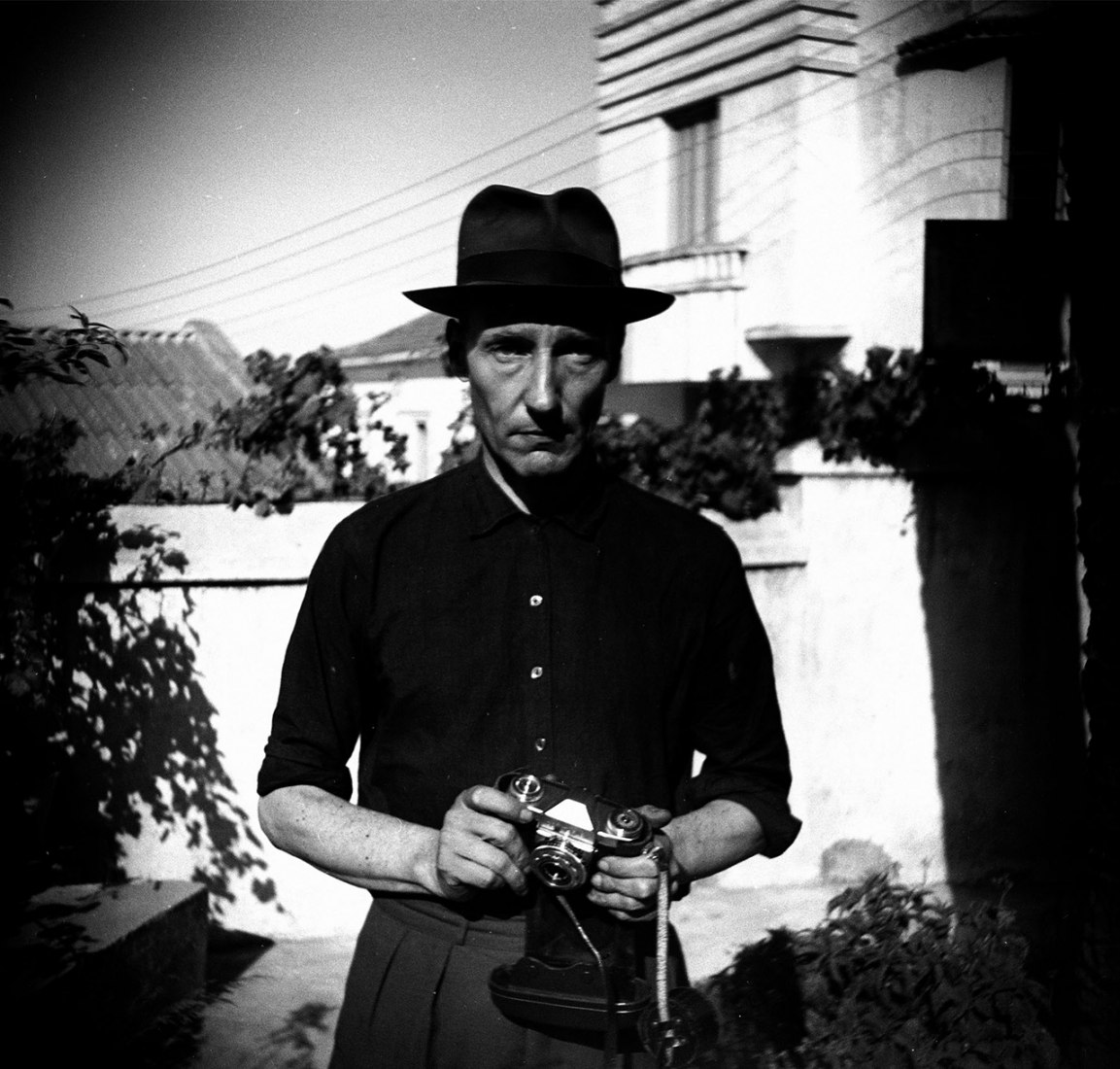 Burroughs at the Hotel Villa Mourniria Garden, unknown photographer, scanning the negative, 5.6 x 5.8 cm. Photography © Estate of William S. Burroughs.