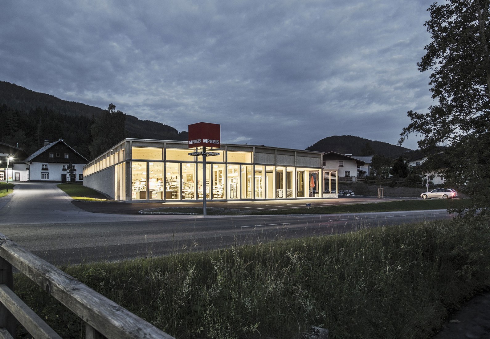 Vista exterior nocturna. Vista interior. LP architektur ganan el premio "best architects 18 award" en la categoría de edificios comerciales/industriales por el MPREIS St. Martin. Fotografía © Albrecht Imanuel Schnabel