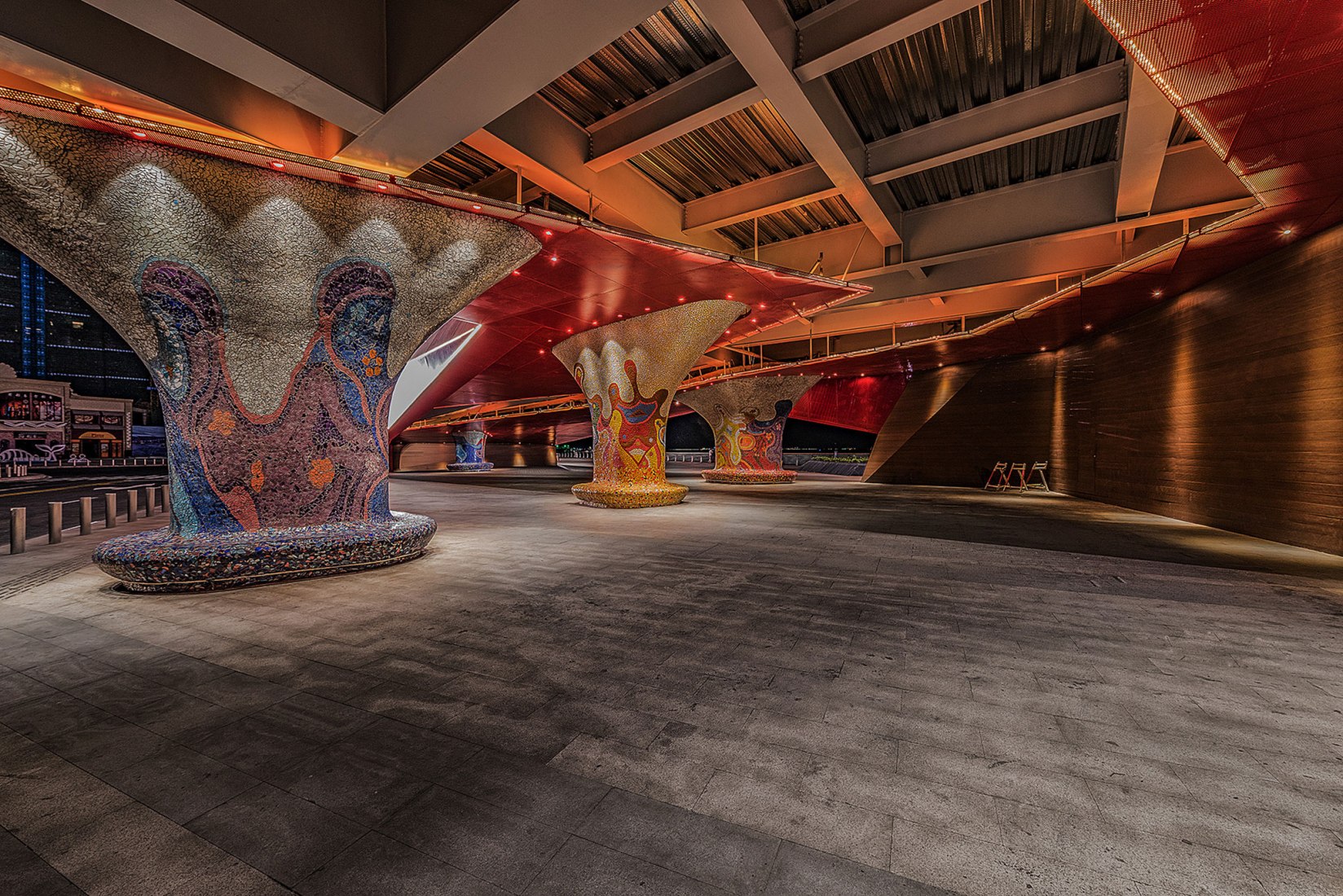 Arte del mosaico de cerámica de Antonio Gaudí de noche. Qingdao Wanda Victoria Bay Xifeng Bridge por PT Architecture Design. Fotografía © PT Landscape