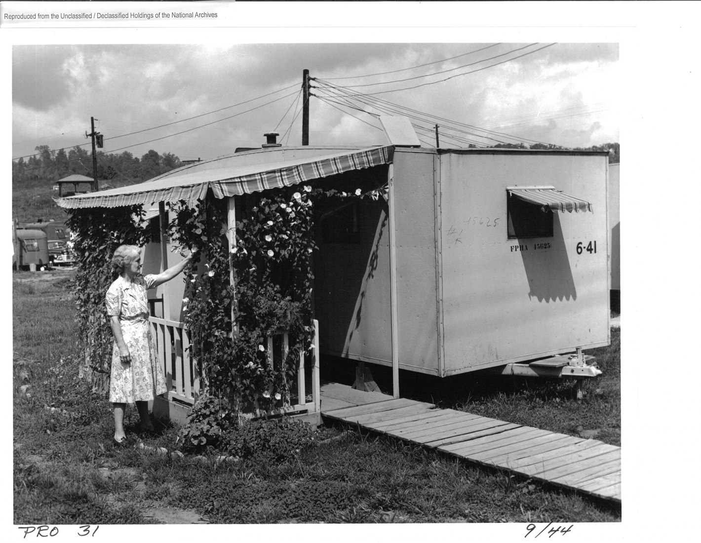 Trailer with decorative trellis, Oak Ridge, 1944. Residents of the Manhattan Project sites worked hard to make their dwellings as attractive and pleasant as possible, even when those dwellings were crude, government-issued trailers. Note the identifying numbers stamped and written on the side of the trailer. Photo by Edward Westcott. National Archives and Records Administration