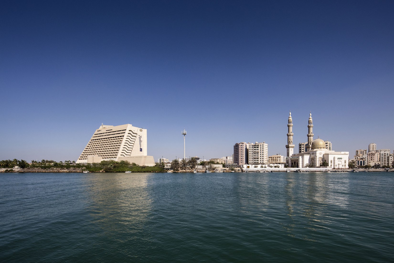 Coastal view of Radisson Blu Resort and Al Maghfirah Mosque, Corniche Street, Sharjah.Sharjah Architecture Triennial: the first international platform on architecture in the MENASA region. Photograph by Ieva Saudargaite
