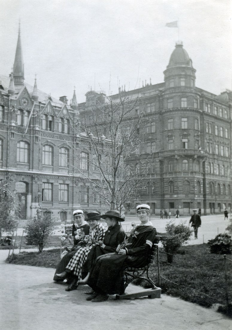 Los estudiantes de arquitectura Toini Ojala, Salme Setälä, Sylvi Nyyssönen y Annikki Paasikivi sentados en el parque frente a la escuela mixta de lengua sueca (actual Museo del Diseño). 1910s. © MFA. Fotografía del álbum de Salme Setälä.