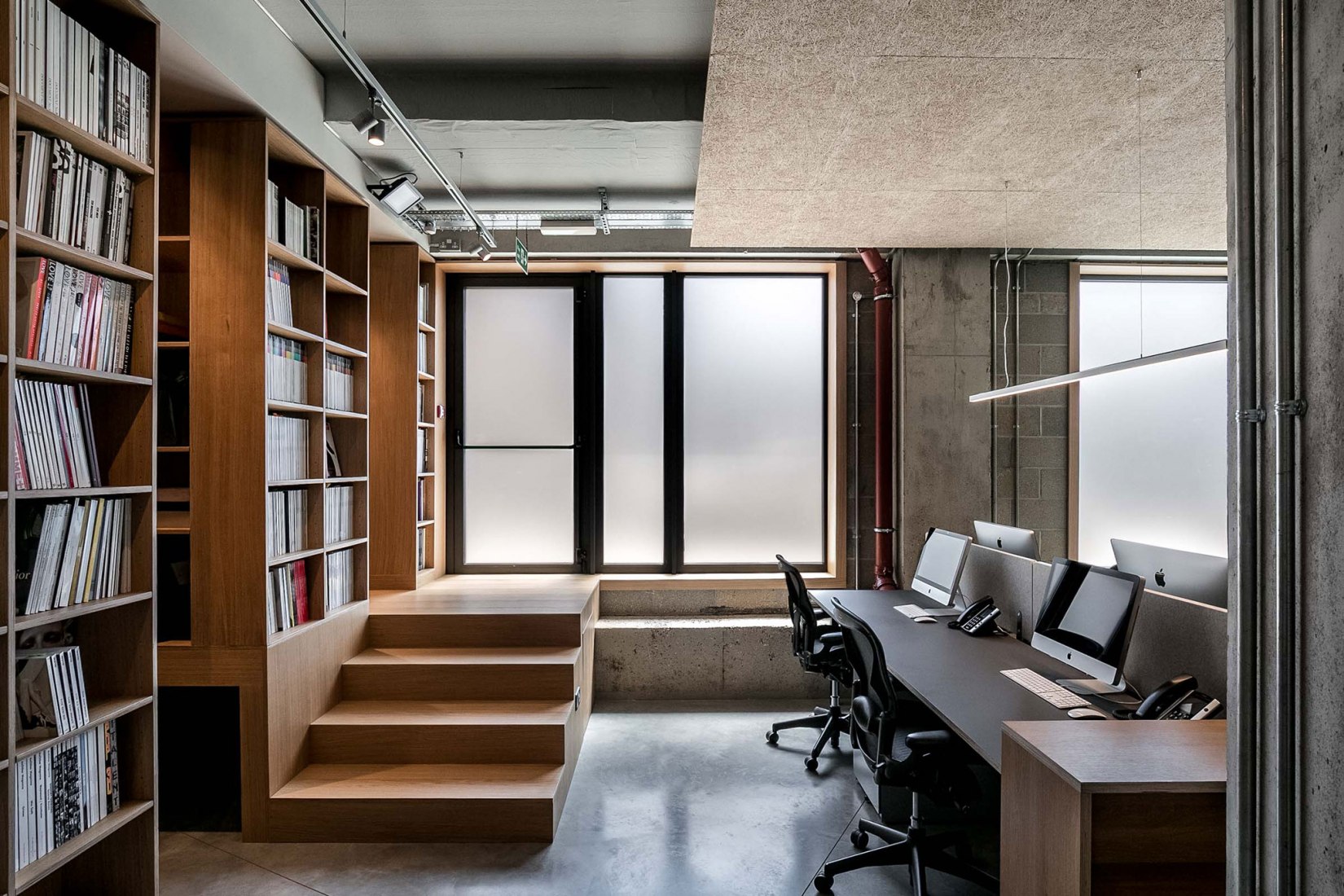 Main office space with stair to the back and book shelves. Creative Agency Dalston-N16 by VOSS Architects. Photograph by Taran Wilkhu Photography