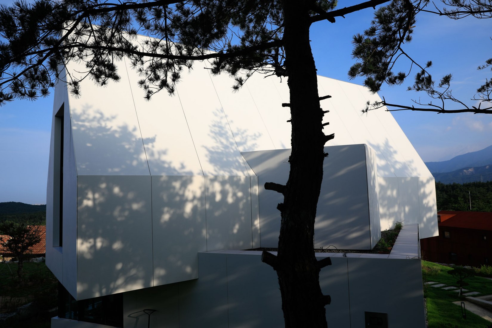 Exterior. House [in white] by AEV Architectures. Photograph by Hyunjune Lee