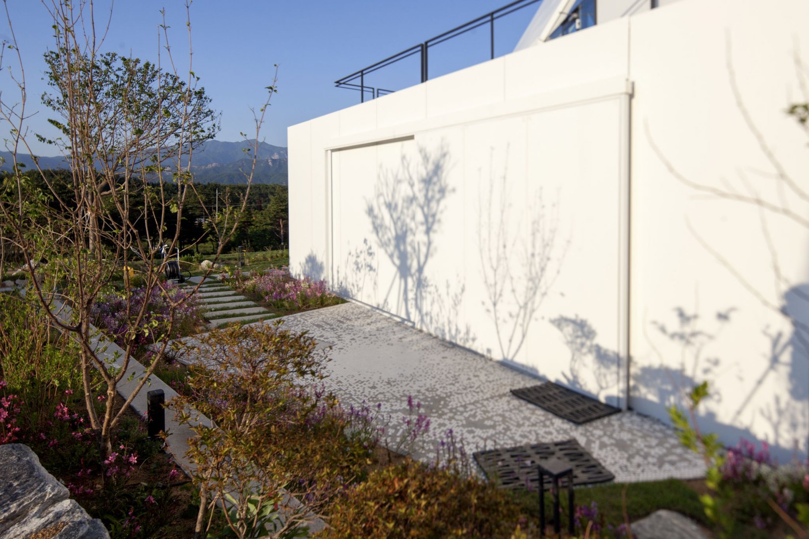 Facade detail. House [in white] by AEV Architectures. Photograph by Hyunjune Lee