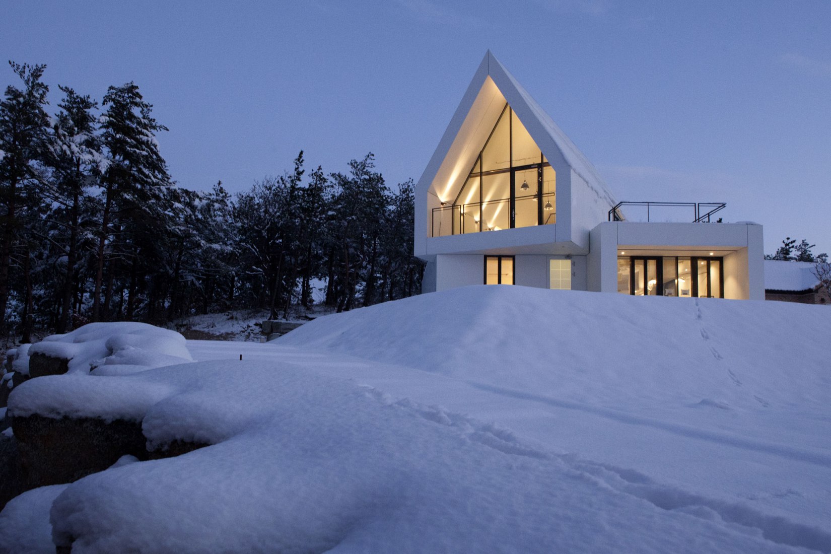 Night view. House [in white] by AEV Architectures. Photograph by Hyunjune Lee