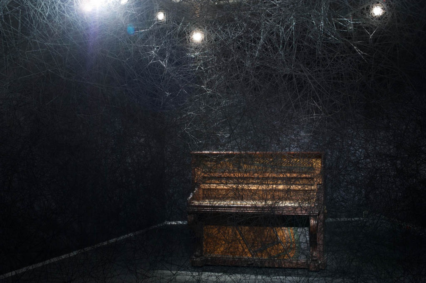 "In silence". Black wool, old piano. "Synchronizing Strings and Rhizomes " by Chiharu Shiota. Photography © Sunhi Mang