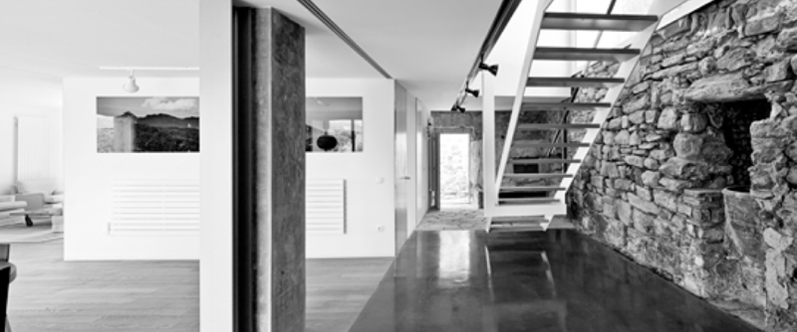 Compartiendo protagonismo con este edificio, la reconstrucción de la antigua mansión rural de La Garrotxa (Girona), donde toda la intervención gravita alrededor del muro de piedra que ancla la casa a la montaña para contener la tierra.. Interior de la casa de campo en  La Garrotxa. Fotografía ©Adrià Goula