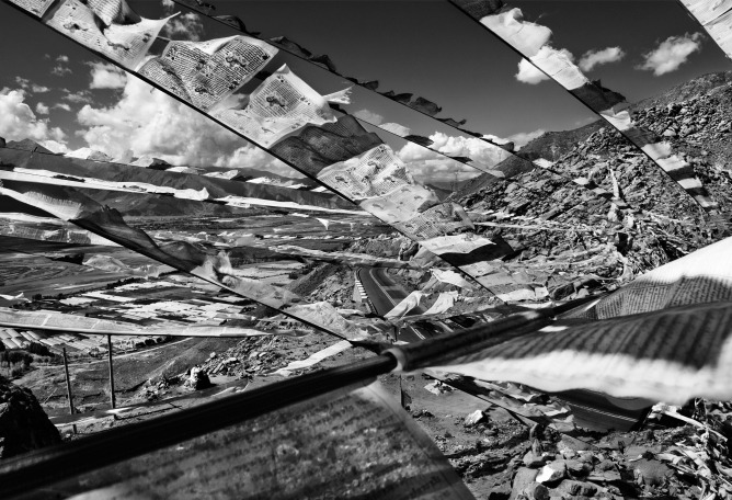 Banderas de plegarias tibetanas adornan un puerto de montaña sobre la carretera Kapa-Lhasa. Hacia abajo, fueron instalados invernaderos agrícolas en terrenos irrigados por los trabajos sobre el río. Kapa, Xizang Tíbet, China. 25/09/2008. Piezografía sobre papel Canson Arche, 60 x 80 cm. Ed. of 15.