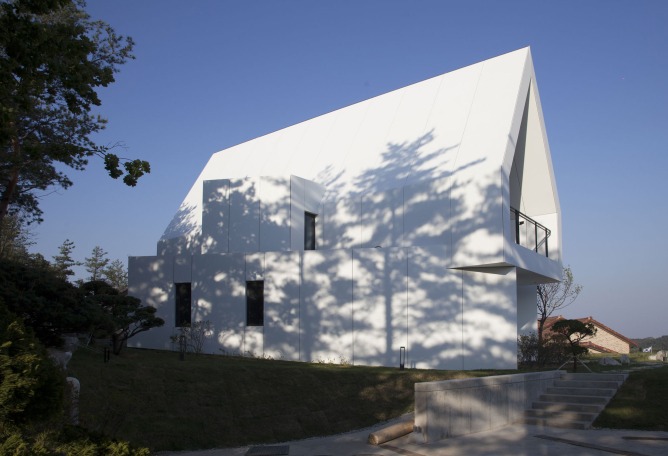 Exterior. House [in white] by AEV Architectures. Photograph by Hyunjune Lee